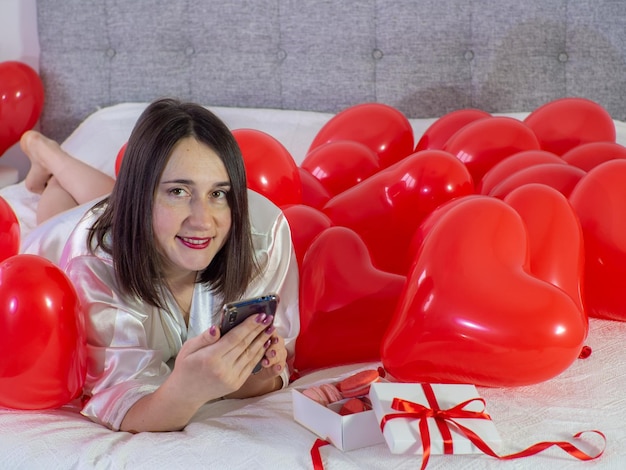 Mujer acostada en decoraciones con globos para la fiesta del Día de San Valentín