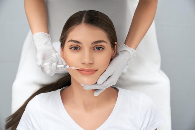 Foto mujer acostada sobre procedimiento de aumento de labios