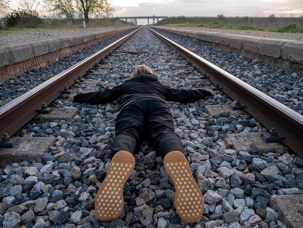 Mujer acostada en las vías del tren