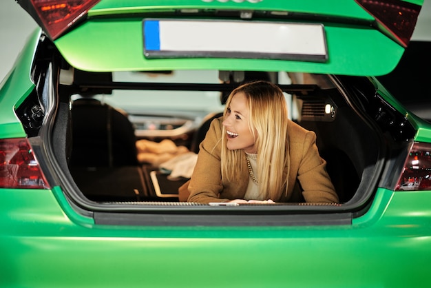 mujer, con, acostado, en, baúl, en, estacionamiento