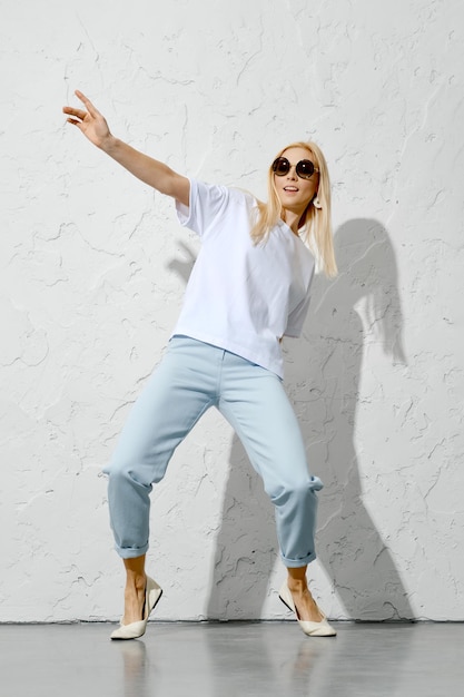 Mujer activa en jeans azules y camisa blanca.