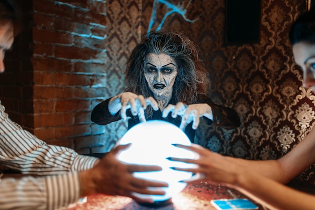 Foto la mujer adivina llama a los espíritus sobre una bola de cristal, brujería.