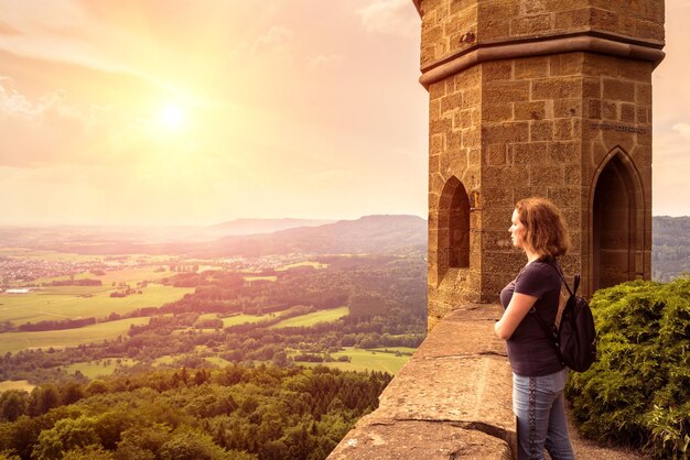 Mujer admira el paisaje al atardecer en el castillo de Hohenzollern Alemania