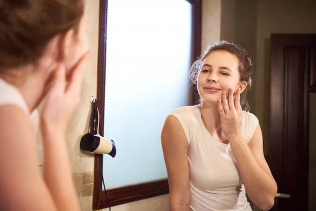 Foto mujer admirando la piel de su cara