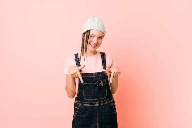 La mujer adolescente de Hispter señala con los dedos, sentimiento positivo.