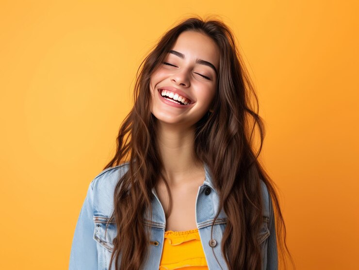 Mujer adolescente de moda sonriendo sobre un fondo amarillo