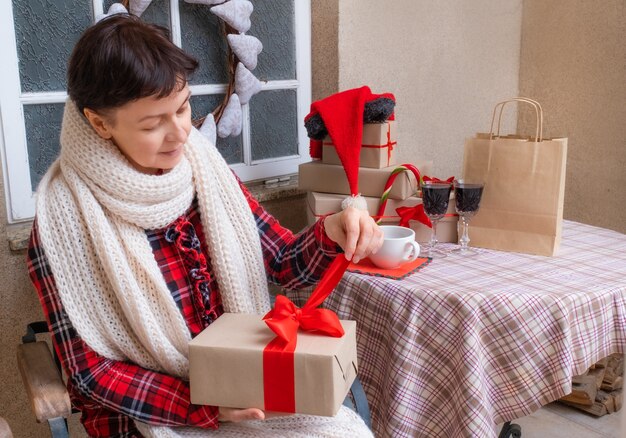 Mujer adulta abriendo regalos de Navidad