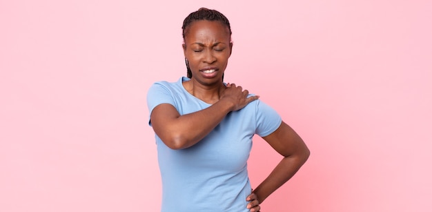 Mujer adulta afro negra que se siente cansada, estresada, ansiosa, frustrada y deprimida, que sufre de dolor de espalda o cuello