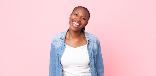 Foto mujer adulta afro negra con una sonrisa grande, amigable y despreocupada, con un aspecto positivo, relajado y feliz, escalofriante