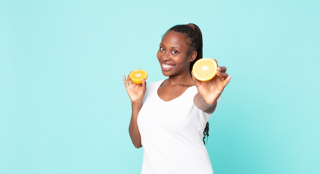 Mujer adulta afroamericana negra. concepto de jugo de naranja