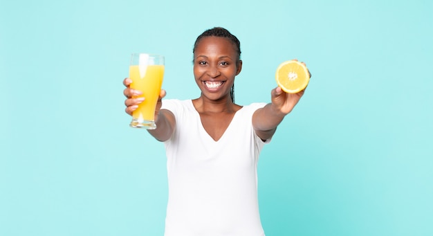 Mujer adulta afroamericana negra. concepto de jugo de naranja