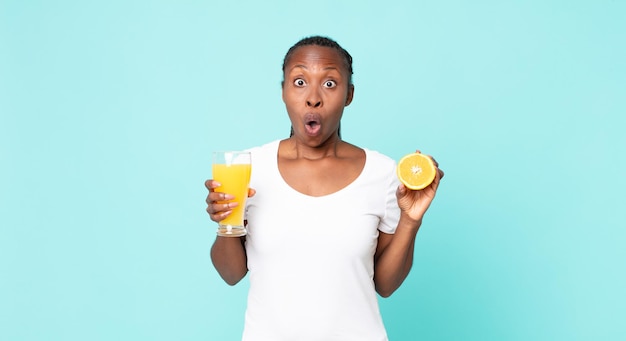 Mujer adulta afroamericana negra. concepto de jugo de naranja