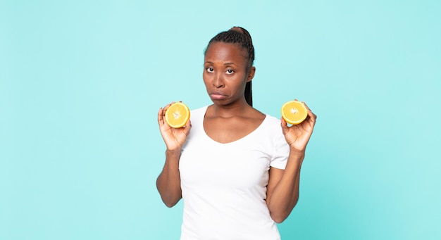 Mujer adulta afroamericana negra. concepto de jugo de naranja