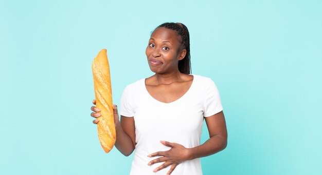 Mujer adulta afroamericana negra sosteniendo una baguette