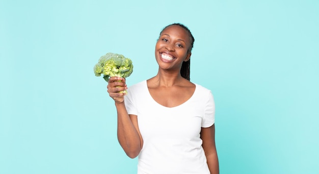 Mujer adulta afroamericana negra sosteniendo un brócoli