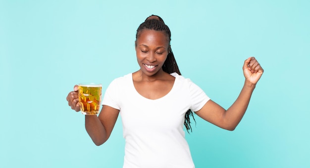 Mujer adulta afroamericana negra y sosteniendo una pinta de cerveza