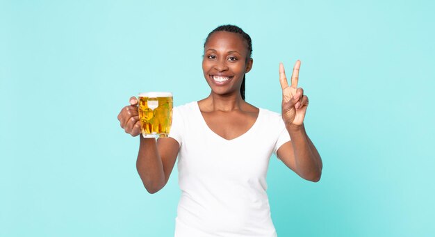 Mujer adulta afroamericana negra y sosteniendo una pinta de cerveza