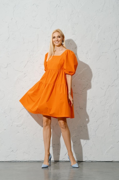 Mujer adulta alegre renunciando a su vestido naranja