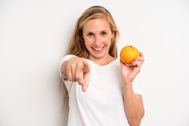 Mujer adulta bastante joven con una naranja