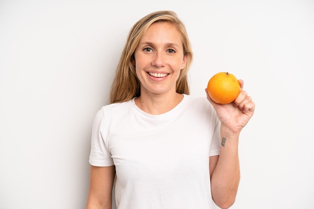 Mujer adulta bastante joven con una naranja