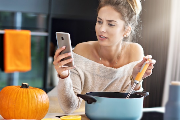 Mujer adulta en la cocina preparando platos de calabaza para Halloween