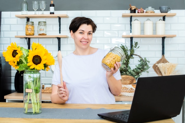 Una mujer adulta está cocinando y sonriendo