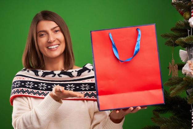 Mujer adulta feliz para compras de regalos de Navidad sobre fondo verde
