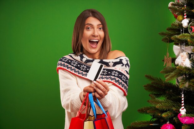 Mujer adulta feliz para compras de regalos de Navidad sobre fondo verde