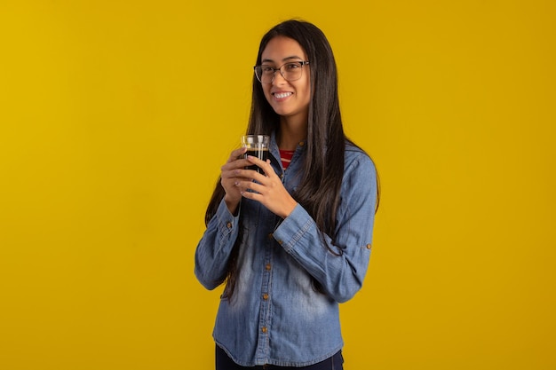 Mujer adulta joven en fotos de estudio haciendo expresiones faciales y sosteniendo una taza de café