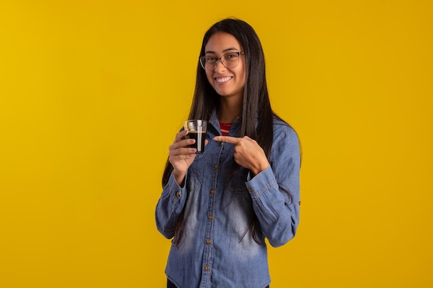 Mujer adulta joven en fotos de estudio haciendo expresiones faciales y sosteniendo una taza de café