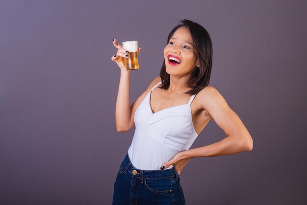 Mujer adulta joven del noreste de Brasil sonriendo bebiendo cerveza bar