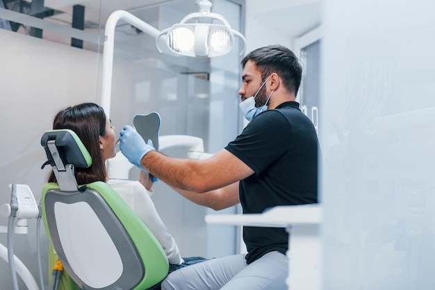 Una mujer adulta joven tiene una visita en la clínica del dentista. Concepción de la estomatología.