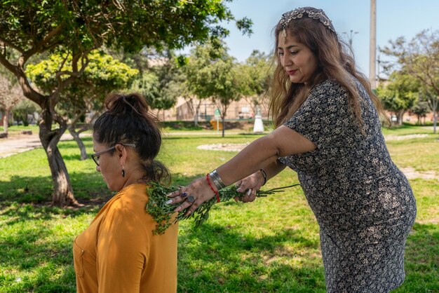 Foto mujer adulta libera a otra mujer de malos pensamientos al pasar ramas