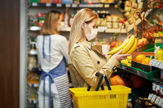 Mujer adulta en máscara médica para compras de comestibles