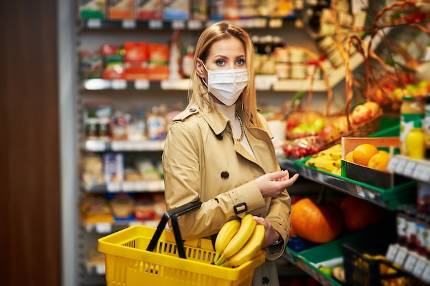 Mujer adulta en máscara médica para compras de comestibles