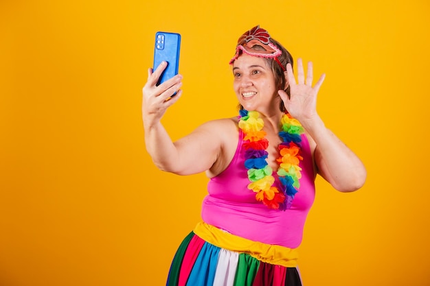 Foto mujer adulta en ropa de carnaval sonriendo a la cámara tomando autorretrato con teléfono inteligente