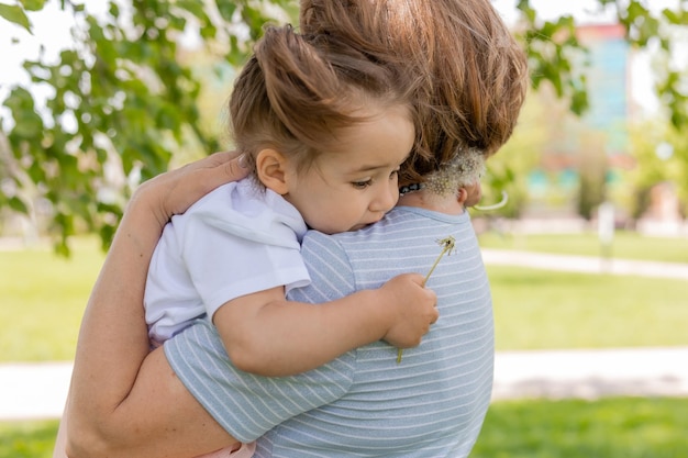 mujer adulta sostiene a una niña en sus brazos la abuela abraza a su nieta