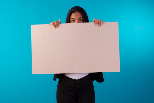 Foto mujer adulta en traje de negocios estilo traje con expresiones faciales y con un cartel.