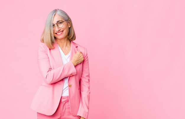 mujer adulta en traje rosa se siente exitosa y motivada