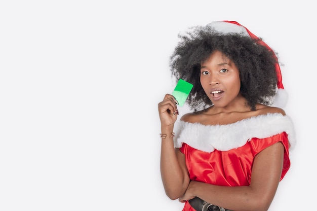 Mujer adulta con un vestido de navidad haciendo un anuncio con una tarjeta verde