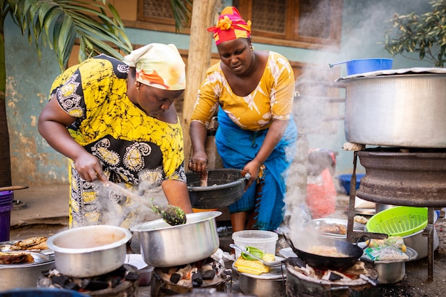 Mujer africana cocinando comida tradicional en la calle