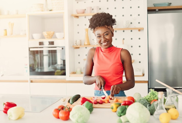 Mujer africana cortando verduras para preparar el desayuno