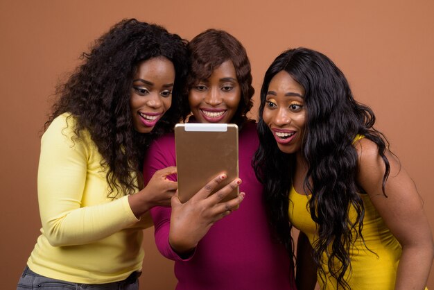 Mujer africana feliz usando tableta digital mientras sonríe