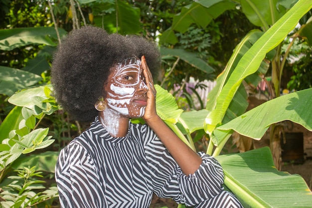 Foto mujer africana con una máscara facial en un campo natural