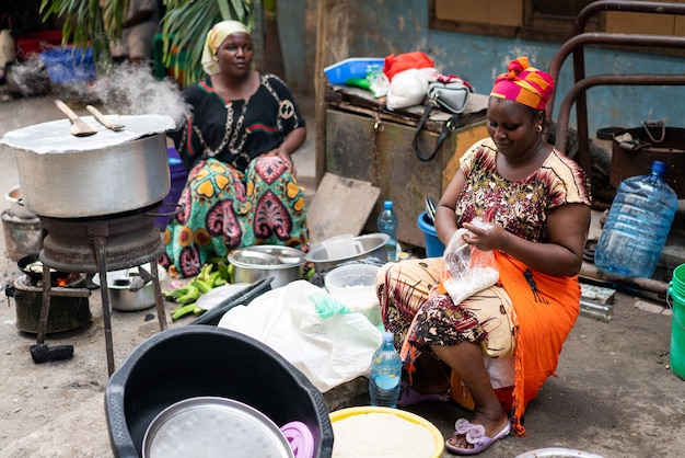 Mujer africana negra cocinando y vendiendo comida en la calle