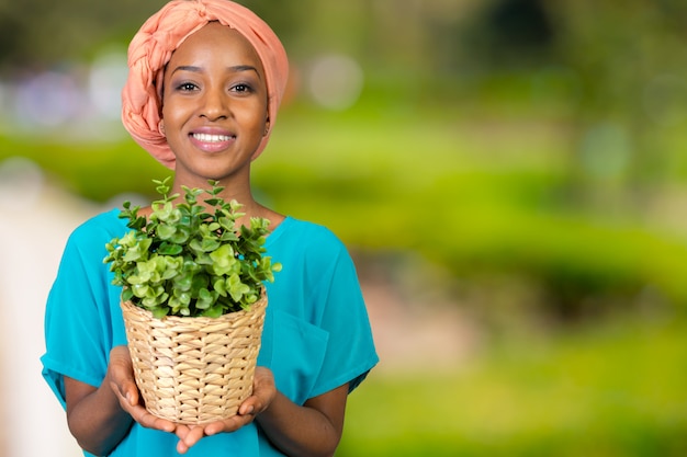 Mujer africana con planta en florero