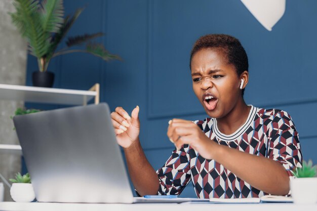 Foto mujer africana que asiste a un seminario en línea hablando agresivamente con colegas hermosa mujer negra oficina inteligente