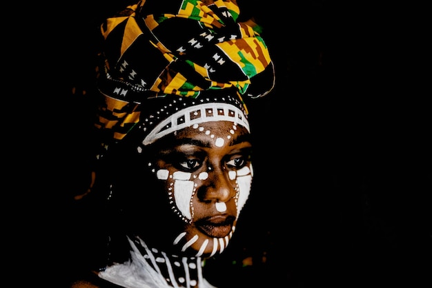 Mujer africana en retrato con pintura facial y tocado