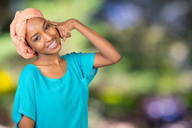 La mujer africana sonriente que hace me llama muestra