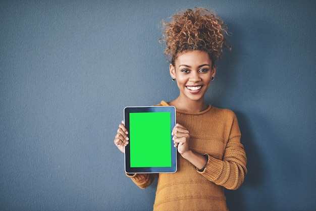 Mujer africana sosteniendo una tableta de pantalla verde